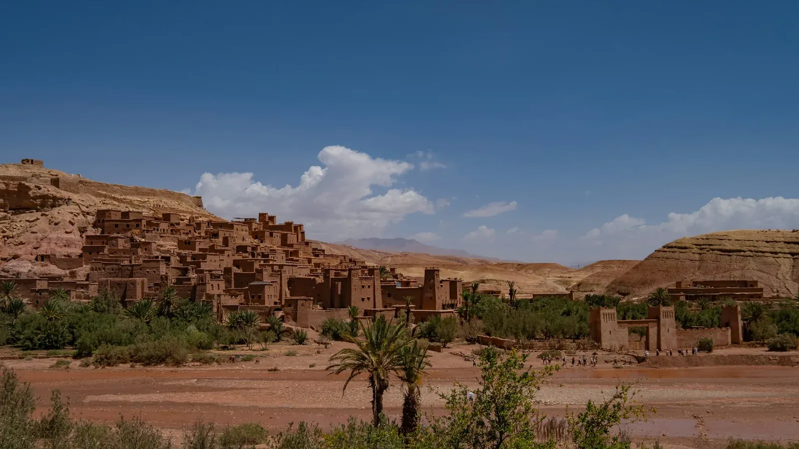 The earthen ksar of Ait Benhaddou with palm trees beside the riverbed