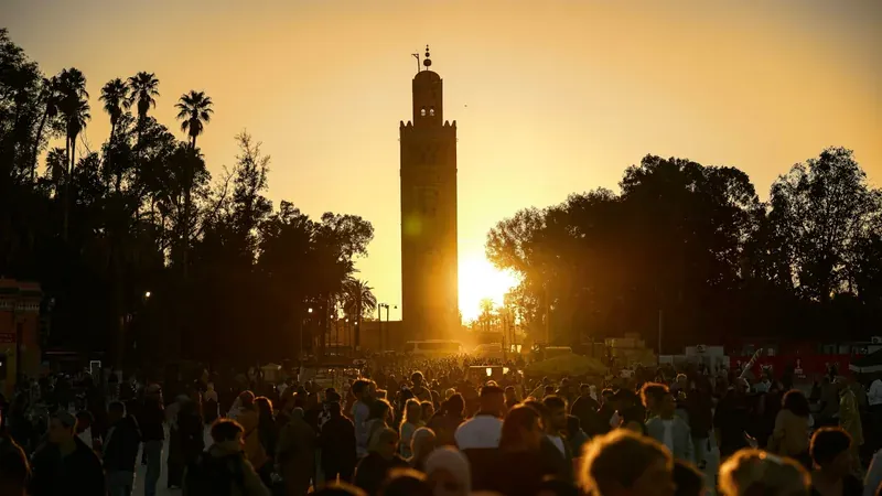 Koutoubia minaret and people in Marrakech at sunset